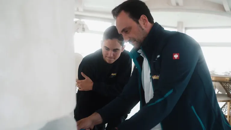 Zwei Mitarbeiter stimmen sich über eine Arbeit an der Wand ab